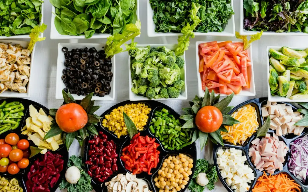 Vegetais folhosos e alimentos ricos em fibra sobre superfície clara